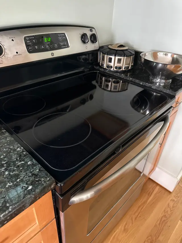 A black glass cooktop and stainless range wiped clean